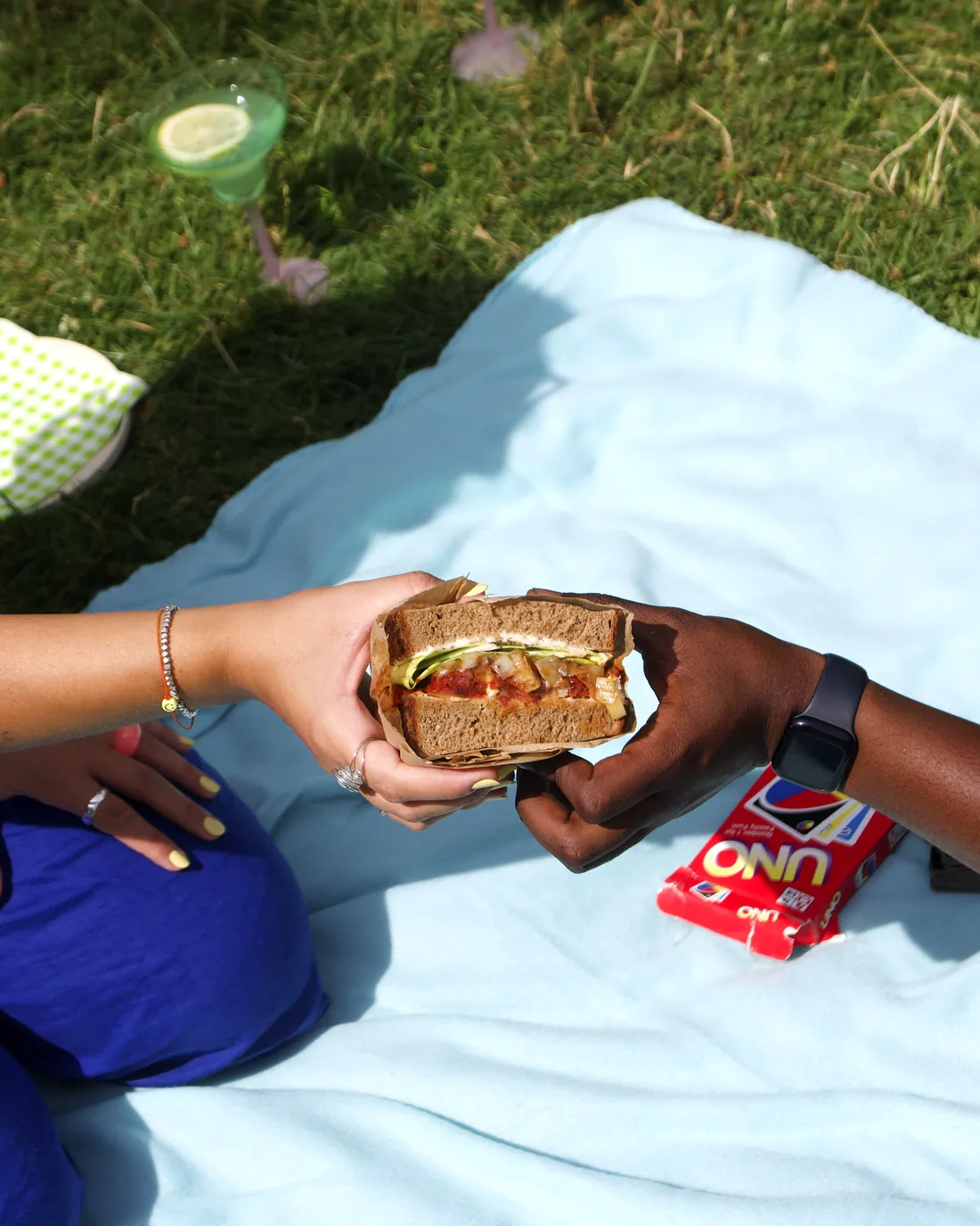 Eine Stulle wird bei einem Picknick von einer Hand in die andere gereicht